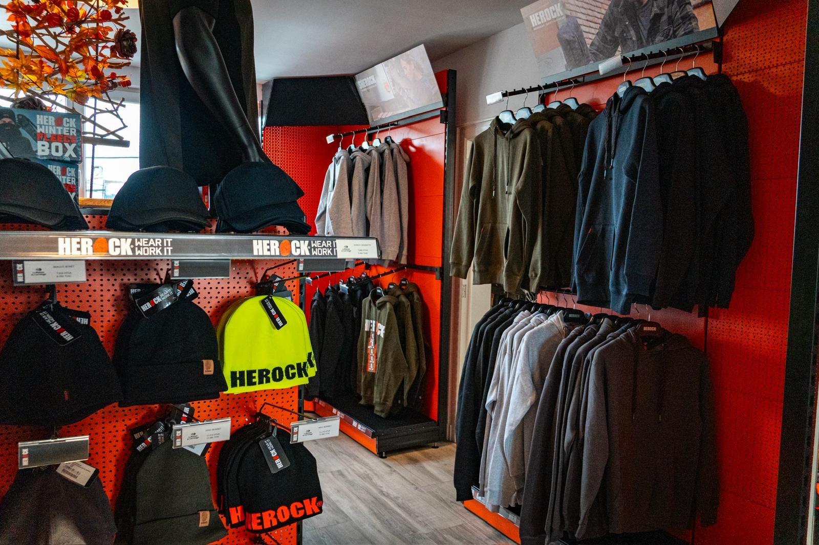 Rayon Herock avec vêtements sur cintres, accessoires suspendus et vêtements pliés.