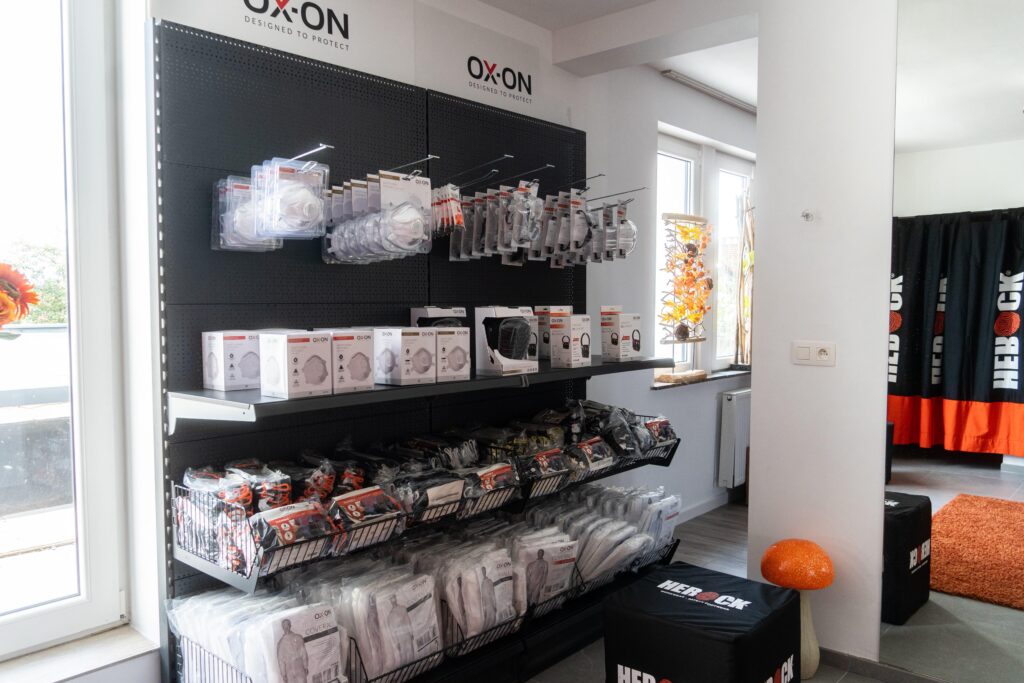 Présentoir OX-ON regroupant des gants et des équipements de travail près de l’entrée du magasin.