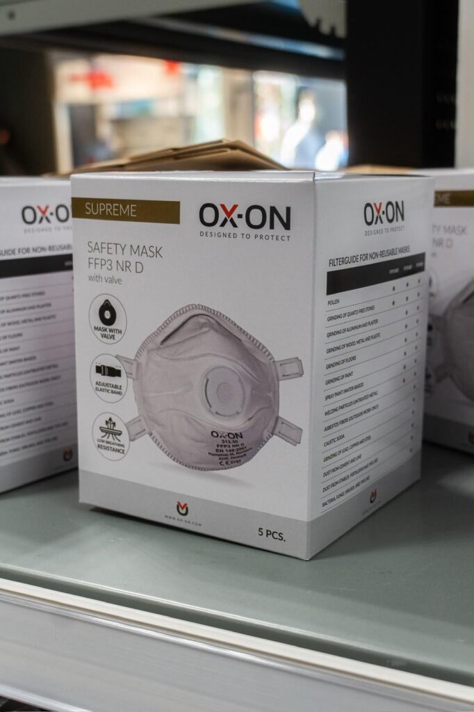 Boîtes de masques de protection OX-ON disposées sur une étagère.