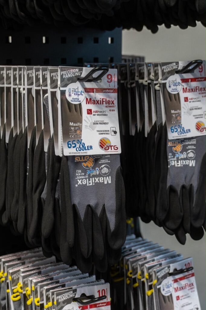 Paires de gants de travail OX-ON suspendues sur un présentoir.